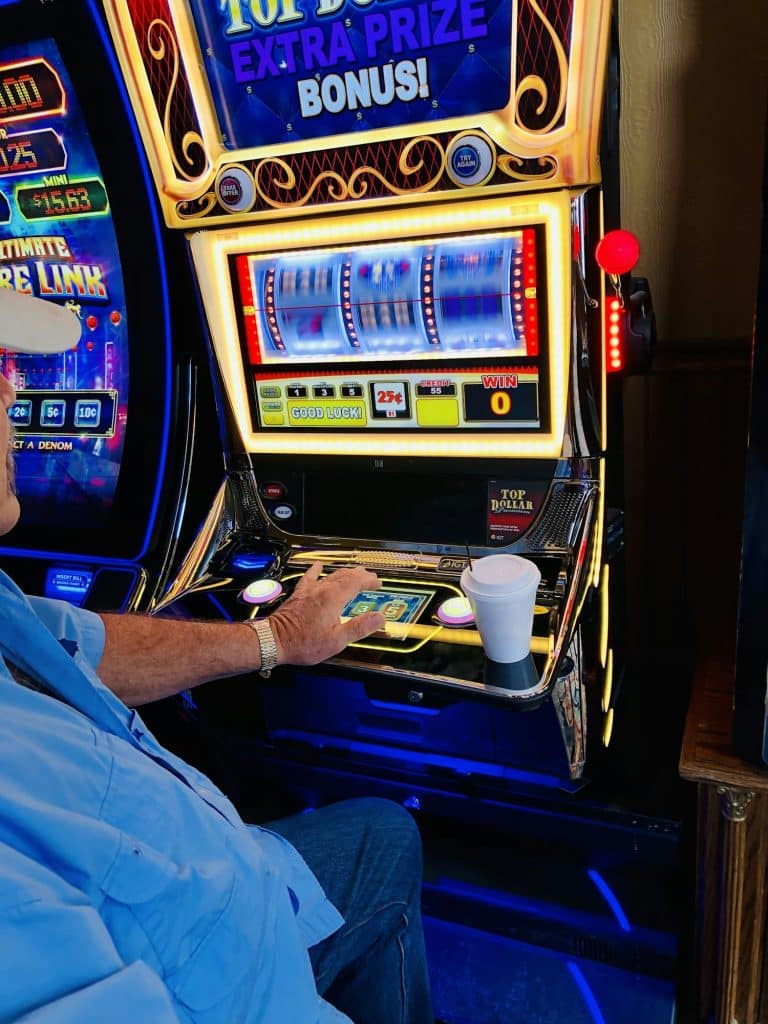 Adult male playing the slot machines.